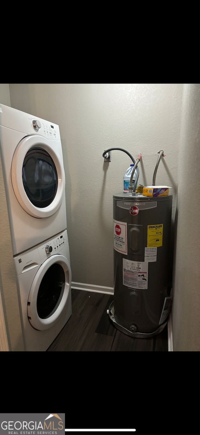 clothes washing area featuring electric water heater, dark hardwood / wood-style floors, and stacked washer / drying machine