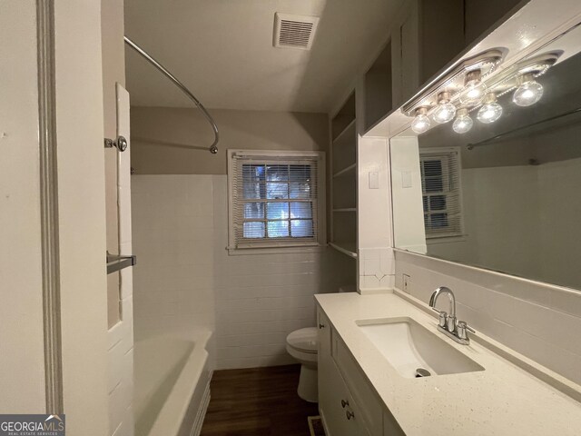 bathroom with decorative backsplash, a shower, vanity, and wood-type flooring