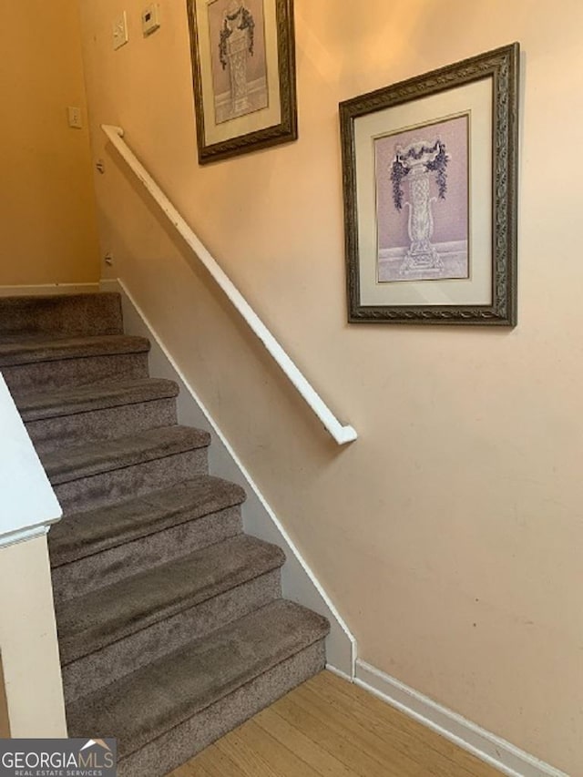 staircase with hardwood / wood-style flooring