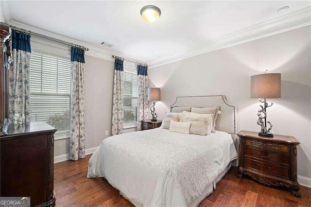 bedroom with dark hardwood / wood-style floors and ornamental molding