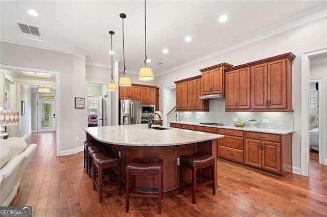 kitchen featuring sink, crown molding, a large island, wood-type flooring, and stainless steel appliances