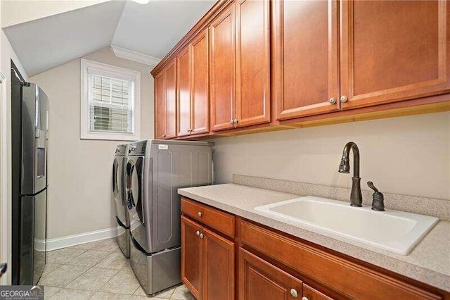 washroom with sink, cabinets, separate washer and dryer, light tile patterned flooring, and ornamental molding