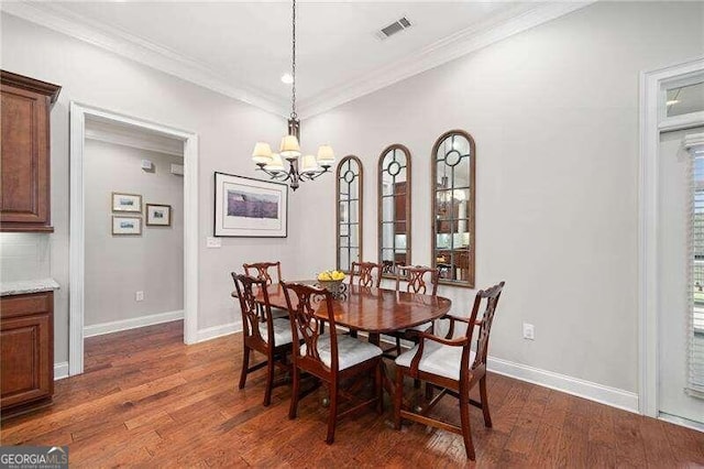 dining space featuring dark wood-type flooring, a notable chandelier, and ornamental molding