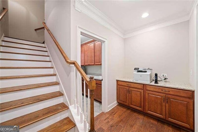 staircase featuring wood-type flooring and crown molding