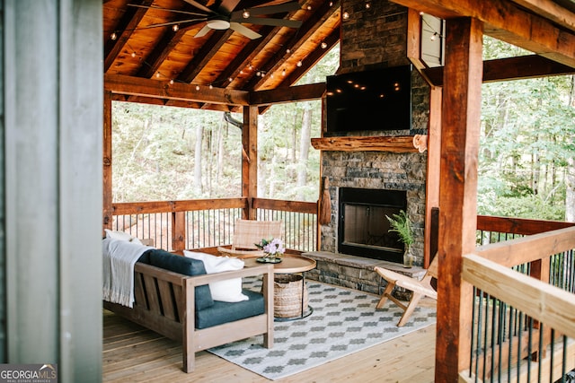 exterior space featuring an outdoor stone fireplace and ceiling fan