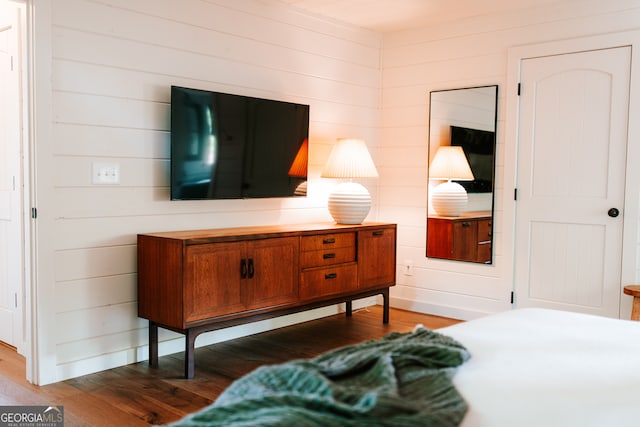 bedroom featuring wood walls and dark wood-type flooring