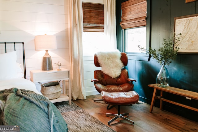 living area with wood walls and wood-type flooring