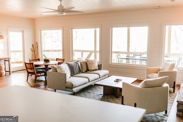 living room featuring ceiling fan, wood ceiling, a wealth of natural light, and light hardwood / wood-style flooring