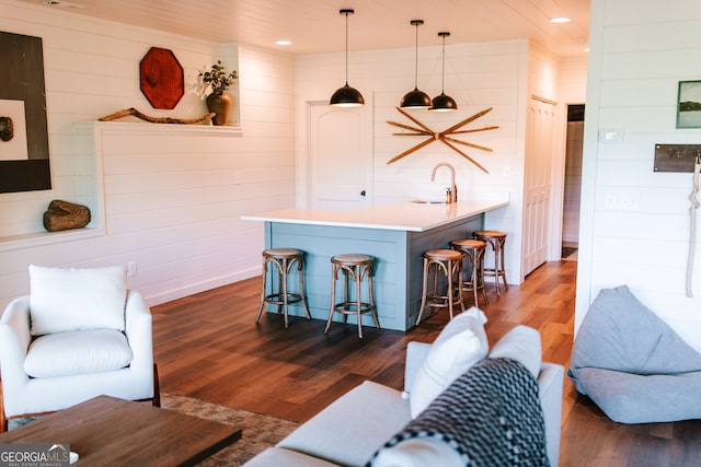 interior space with pendant lighting, sink, and dark wood-type flooring