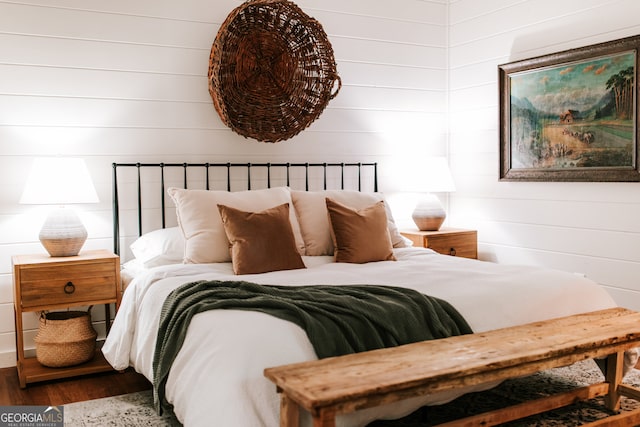 bedroom featuring hardwood / wood-style floors and wooden walls