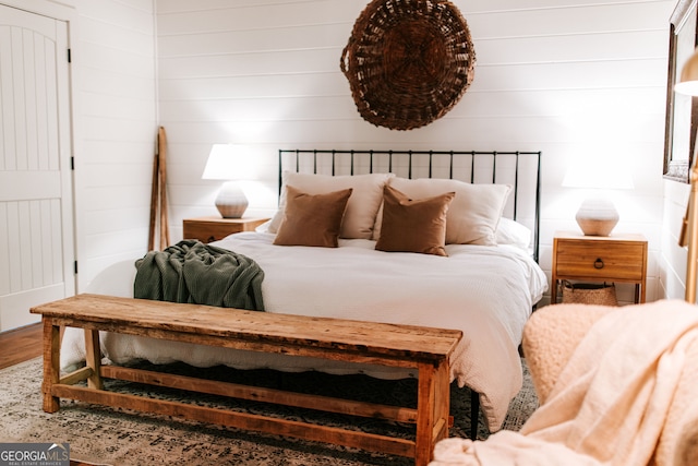 bedroom featuring wood-type flooring and wooden walls