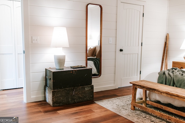 bedroom with wooden walls and hardwood / wood-style flooring