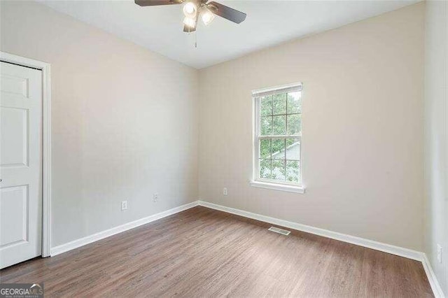 empty room featuring ceiling fan and dark wood-type flooring