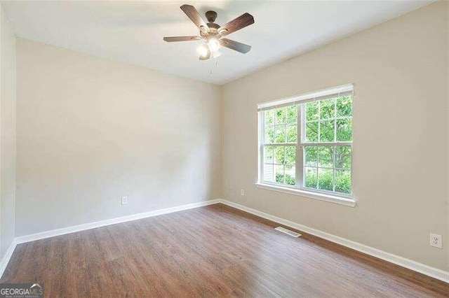 empty room featuring ceiling fan and dark hardwood / wood-style floors