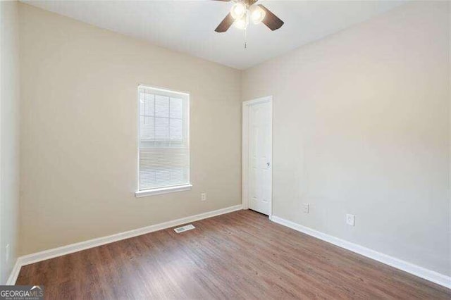 empty room featuring ceiling fan, hardwood / wood-style floors, and a healthy amount of sunlight