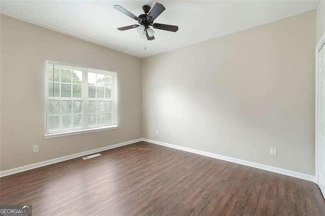 unfurnished room with dark hardwood / wood-style floors and ceiling fan