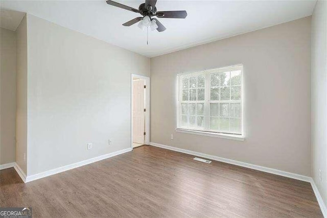 unfurnished room with ceiling fan and dark wood-type flooring