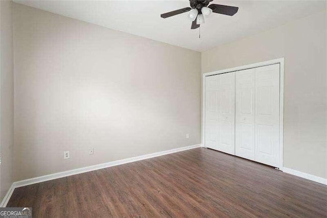 unfurnished bedroom with a closet, dark hardwood / wood-style floors, and ceiling fan