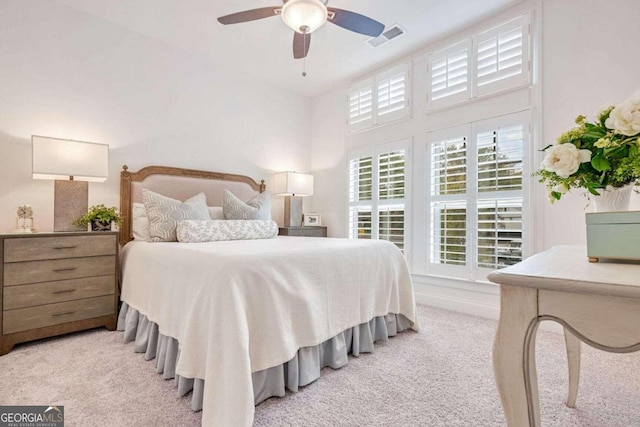 carpeted bedroom with ceiling fan and high vaulted ceiling