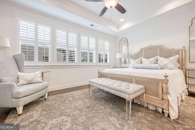 bedroom featuring a tray ceiling, ceiling fan, crown molding, and hardwood / wood-style flooring