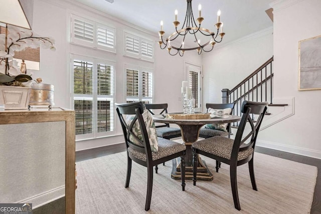 dining area with hardwood / wood-style flooring, an inviting chandelier, and crown molding