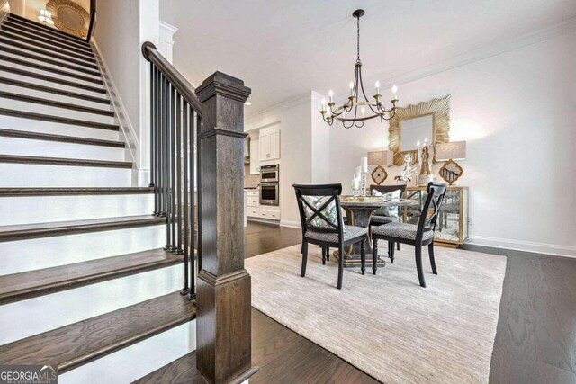 dining area featuring ornamental molding, dark hardwood / wood-style floors, and a notable chandelier