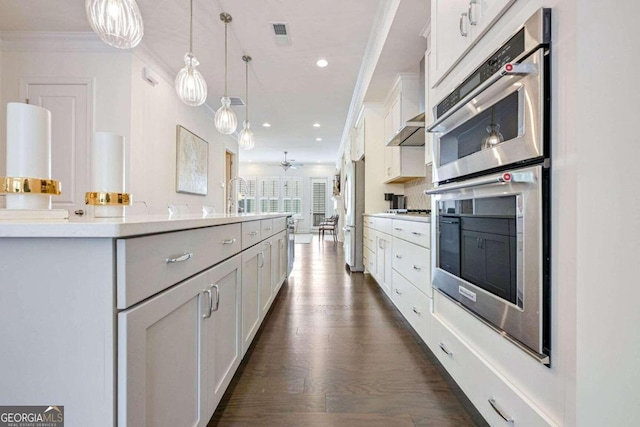 kitchen featuring decorative light fixtures, stainless steel appliances, white cabinetry, and dark wood-type flooring