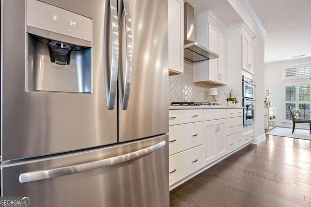 kitchen featuring wall chimney exhaust hood, stainless steel appliances, crown molding, white cabinets, and dark hardwood / wood-style floors