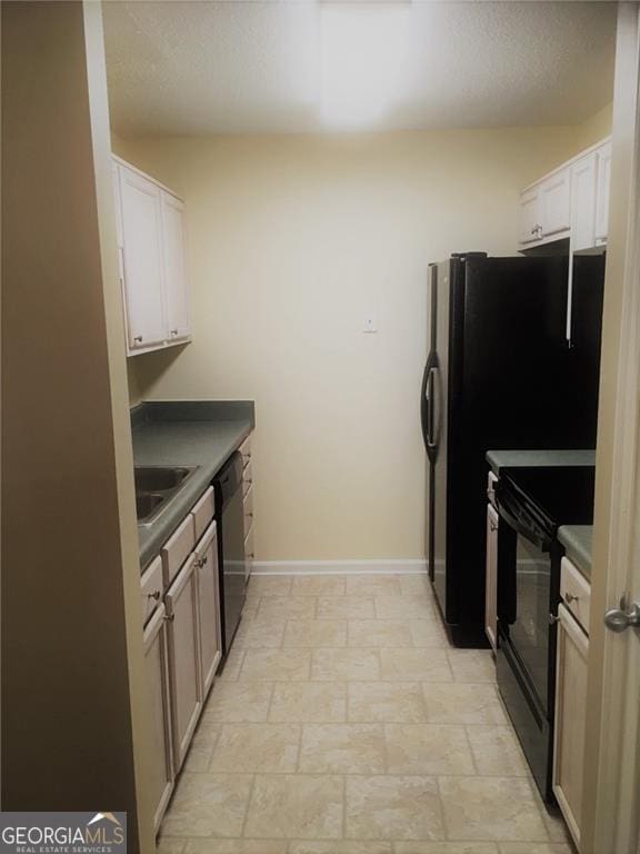 kitchen with dishwasher, black stove, white cabinetry, and sink