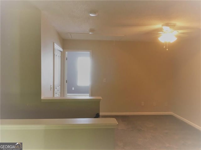 spare room featuring ceiling fan and carpet