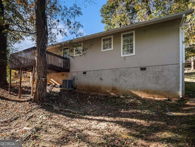 view of home's exterior with cooling unit and a wooden deck