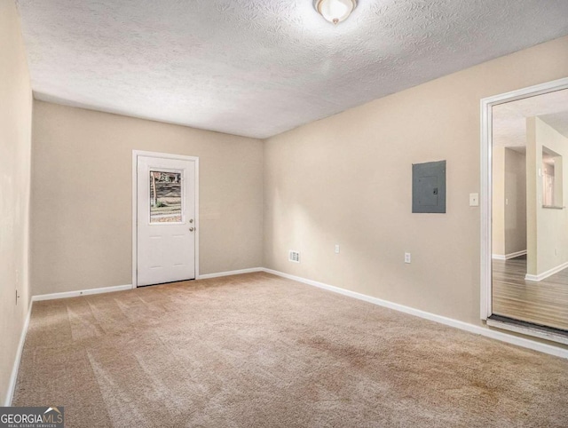 unfurnished room with carpet flooring, electric panel, and a textured ceiling