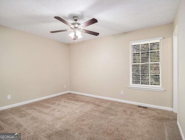 spare room featuring ceiling fan, carpet floors, and a textured ceiling