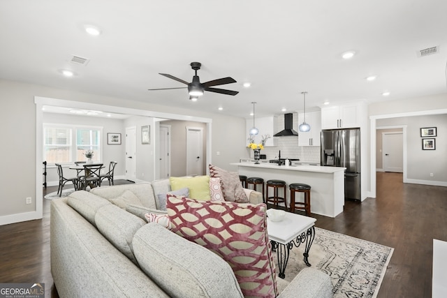 living room featuring ceiling fan and dark wood-type flooring