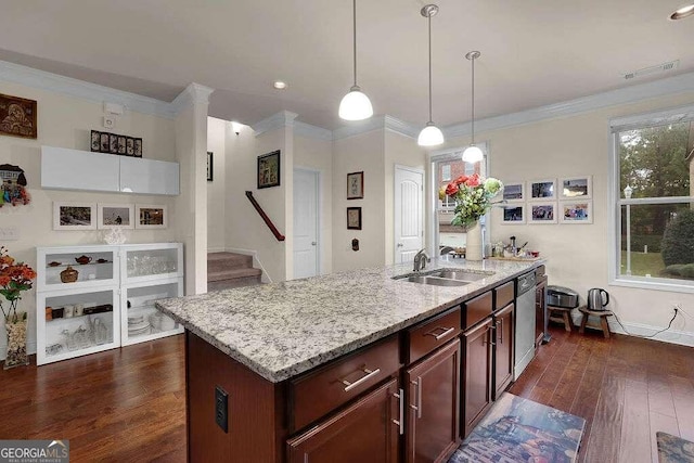 kitchen featuring dishwasher, hanging light fixtures, dark wood-type flooring, crown molding, and a kitchen island with sink