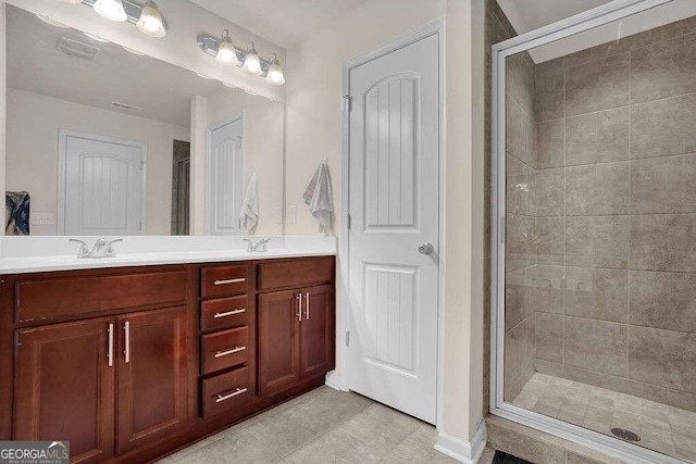 bathroom with tile patterned floors, vanity, and a shower with shower door