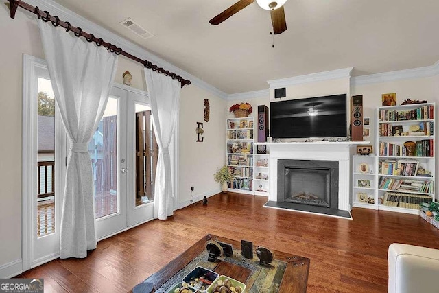 living room with hardwood / wood-style flooring, ceiling fan, and ornamental molding