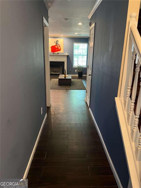 corridor featuring dark hardwood / wood-style flooring and ornamental molding