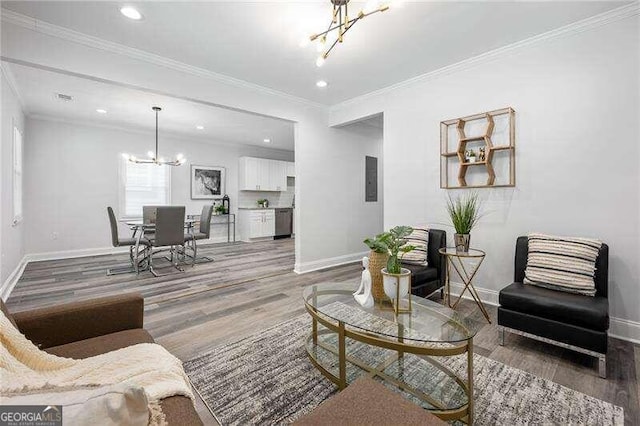 living room with hardwood / wood-style flooring, ornamental molding, and a notable chandelier