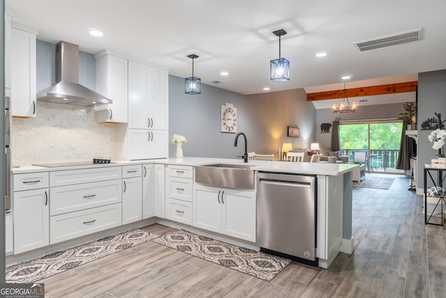 kitchen with stainless steel dishwasher, wall chimney exhaust hood, white cabinetry, and hanging light fixtures