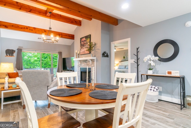 dining area featuring vaulted ceiling with beams, light hardwood / wood-style floors, and an inviting chandelier