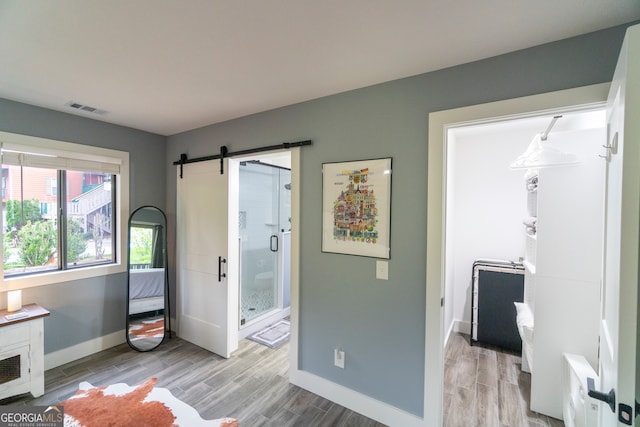 interior space with a barn door and light hardwood / wood-style floors