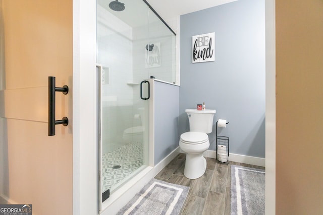 bathroom with a shower with door, wood-type flooring, and toilet