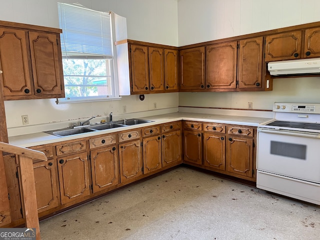 kitchen with white electric range oven, wood walls, and sink