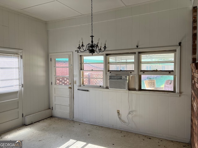 interior space featuring an inviting chandelier, cooling unit, and wooden walls