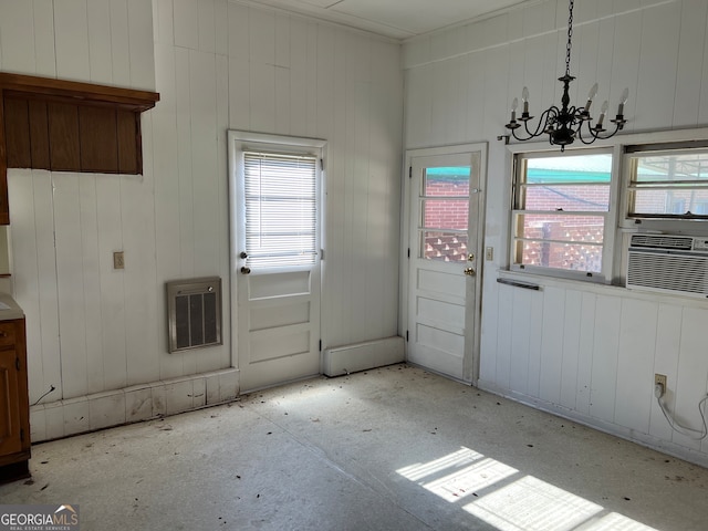 interior space featuring heating unit, an inviting chandelier, cooling unit, and wooden walls