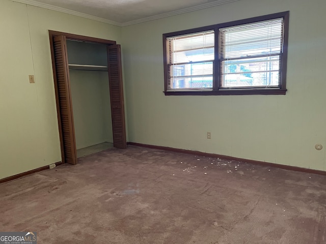 unfurnished bedroom featuring carpet, a closet, and crown molding