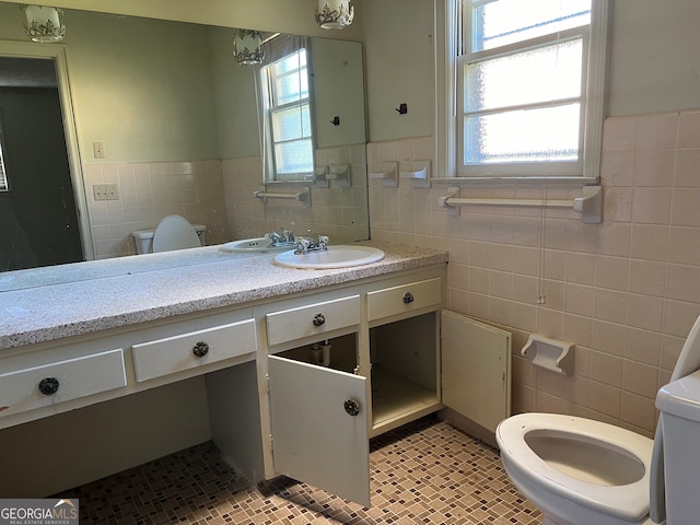 bathroom featuring vanity, tile walls, and toilet