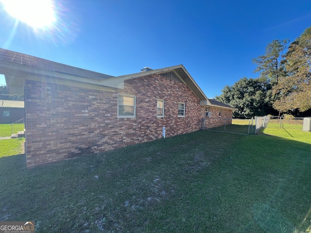 view of side of home with a yard