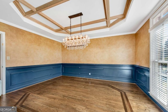 unfurnished room featuring a notable chandelier, dark hardwood / wood-style flooring, and ornamental molding